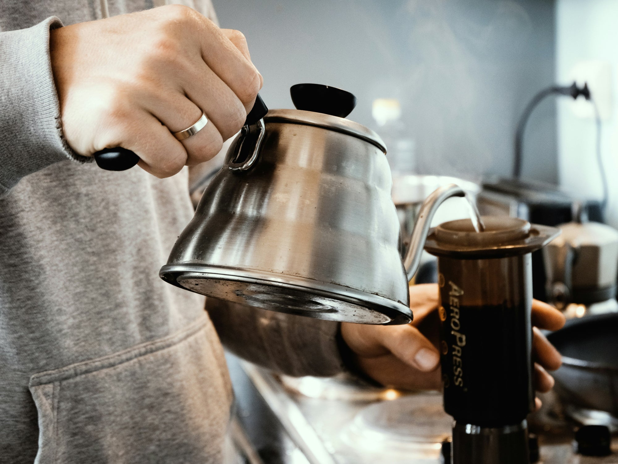 aeropress coffee brewer with gooseneck kettle pouring water into it