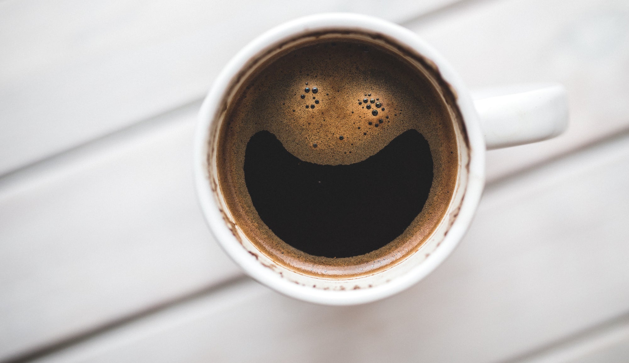 Happy smiling face in coffee foam