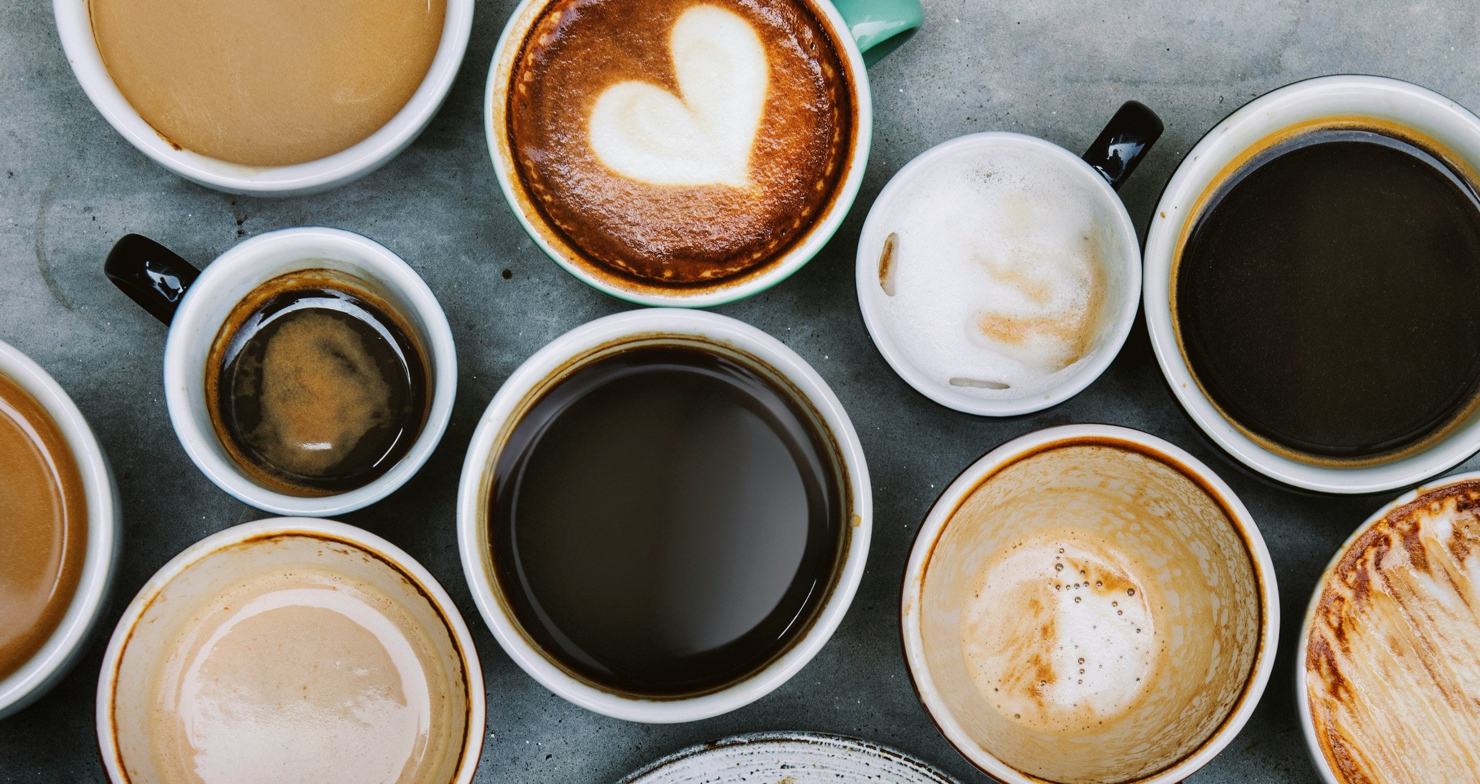 array on coffee cups full of coffee on grey concrete countertop
