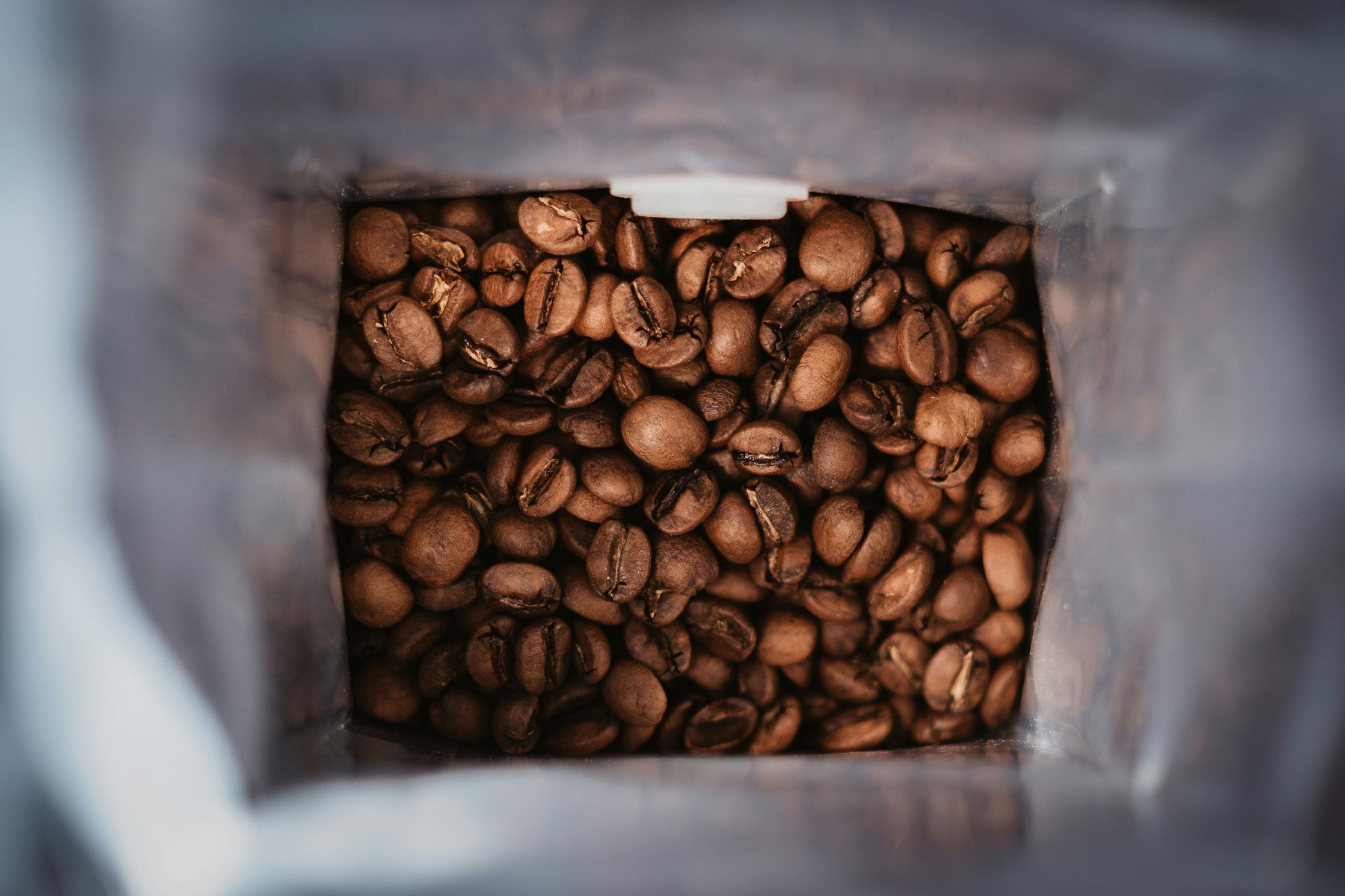 coffee beans in the bottom of a silver foil bag