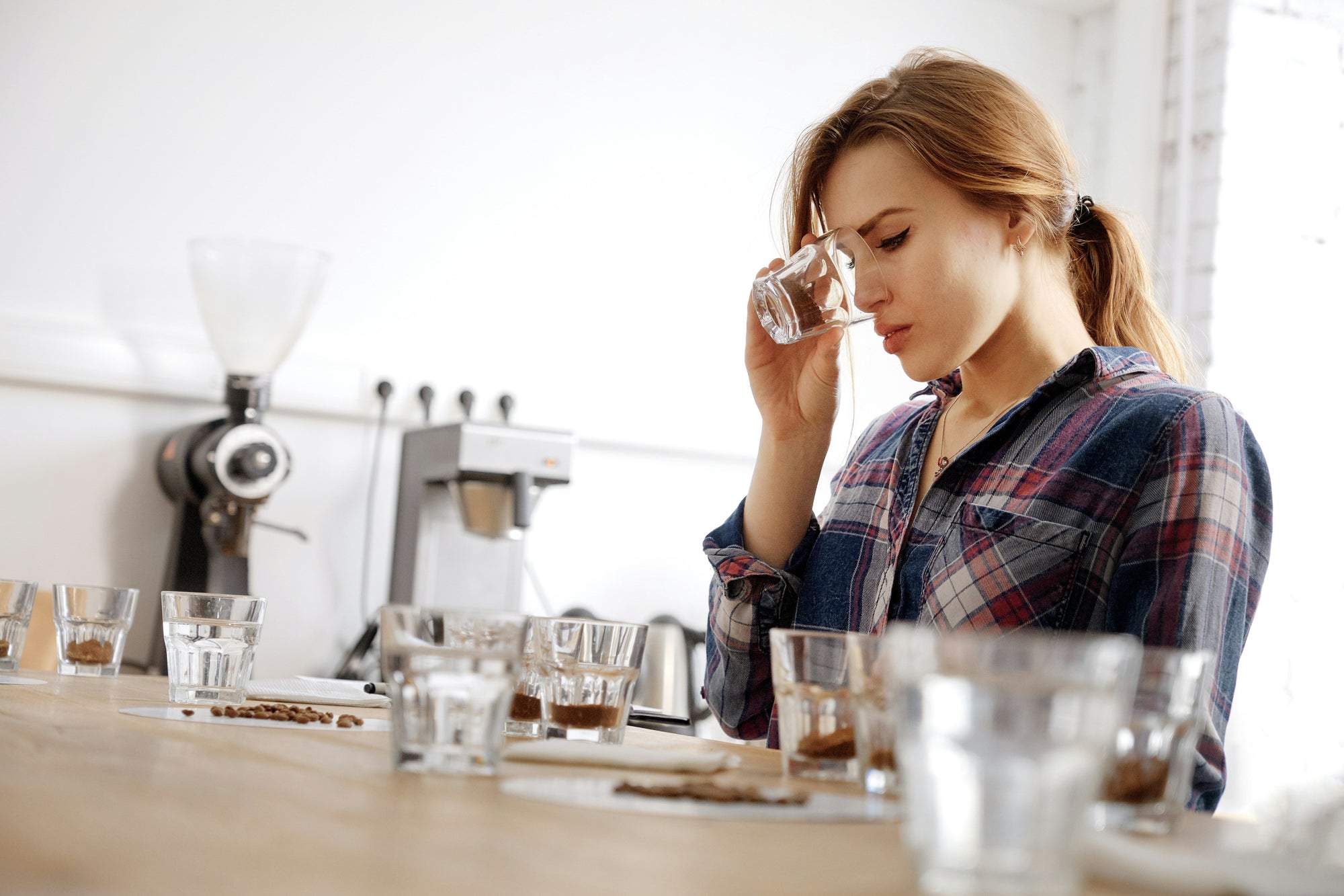 woman smelling coffee as part of coffee cupping