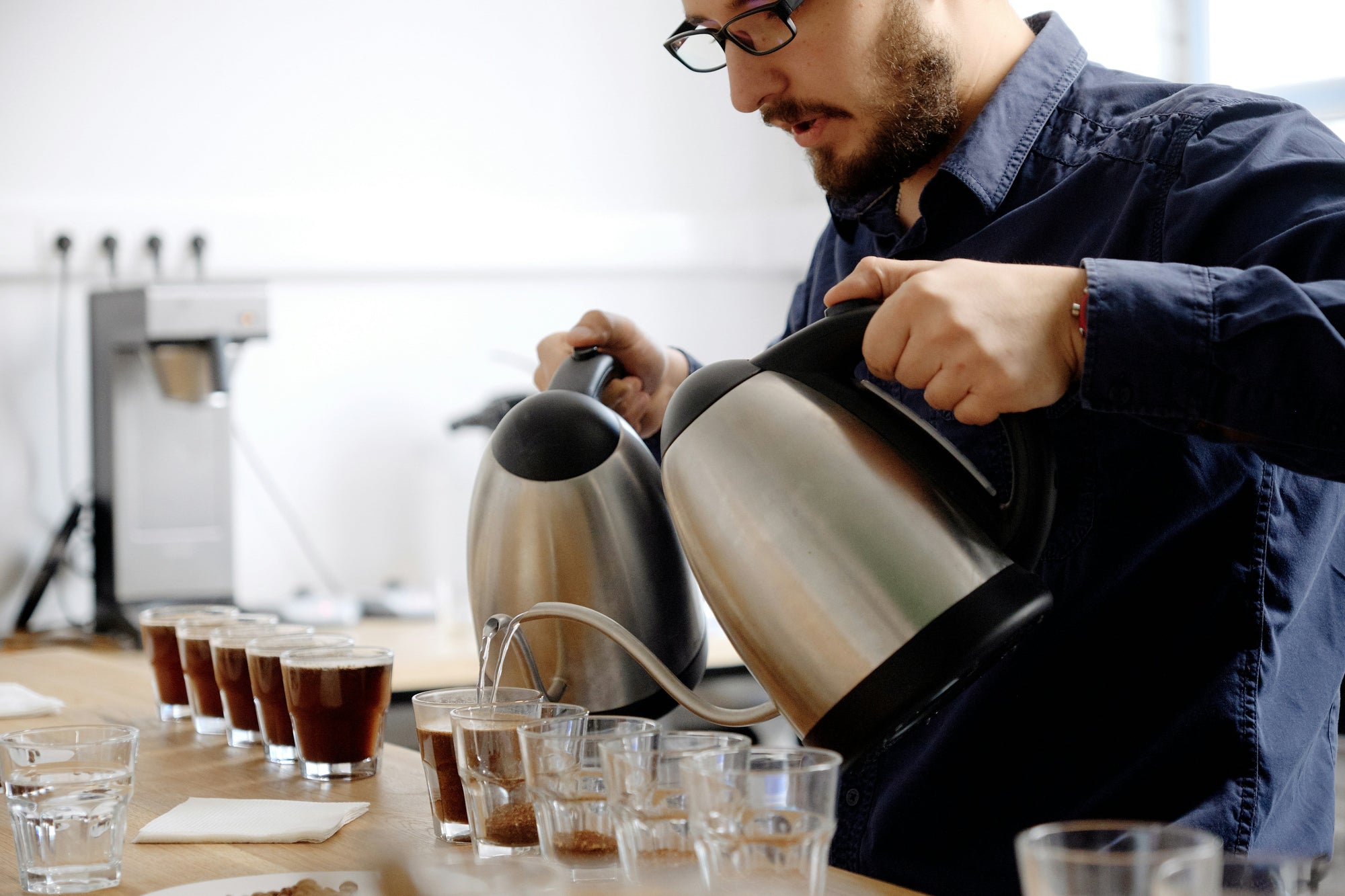 man creating coffee cupping set-up