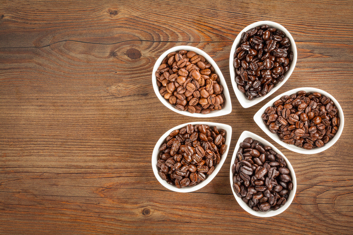 small bowls holding coffee beans on wooden table