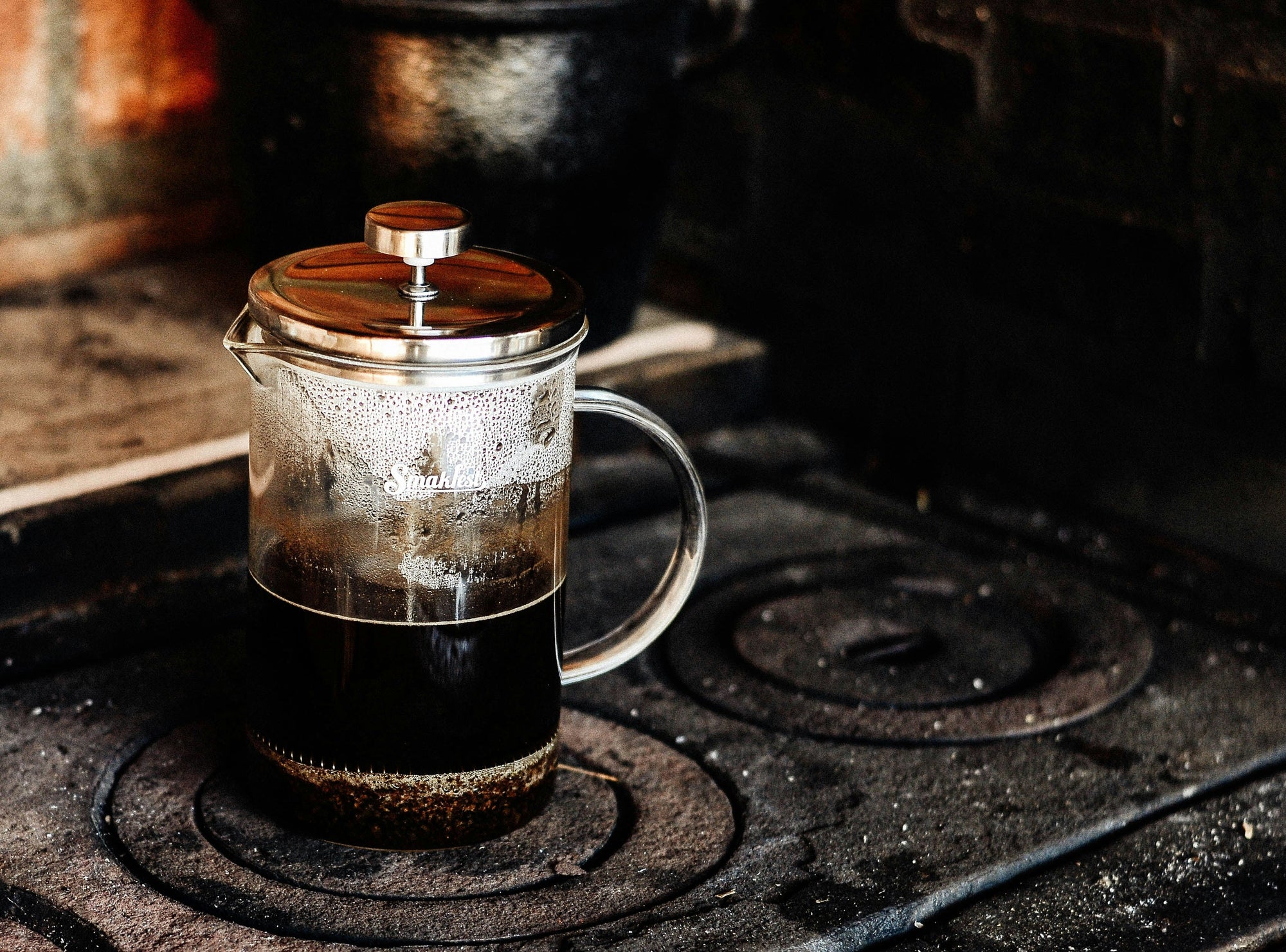 French press coffee maker sitting on stove top