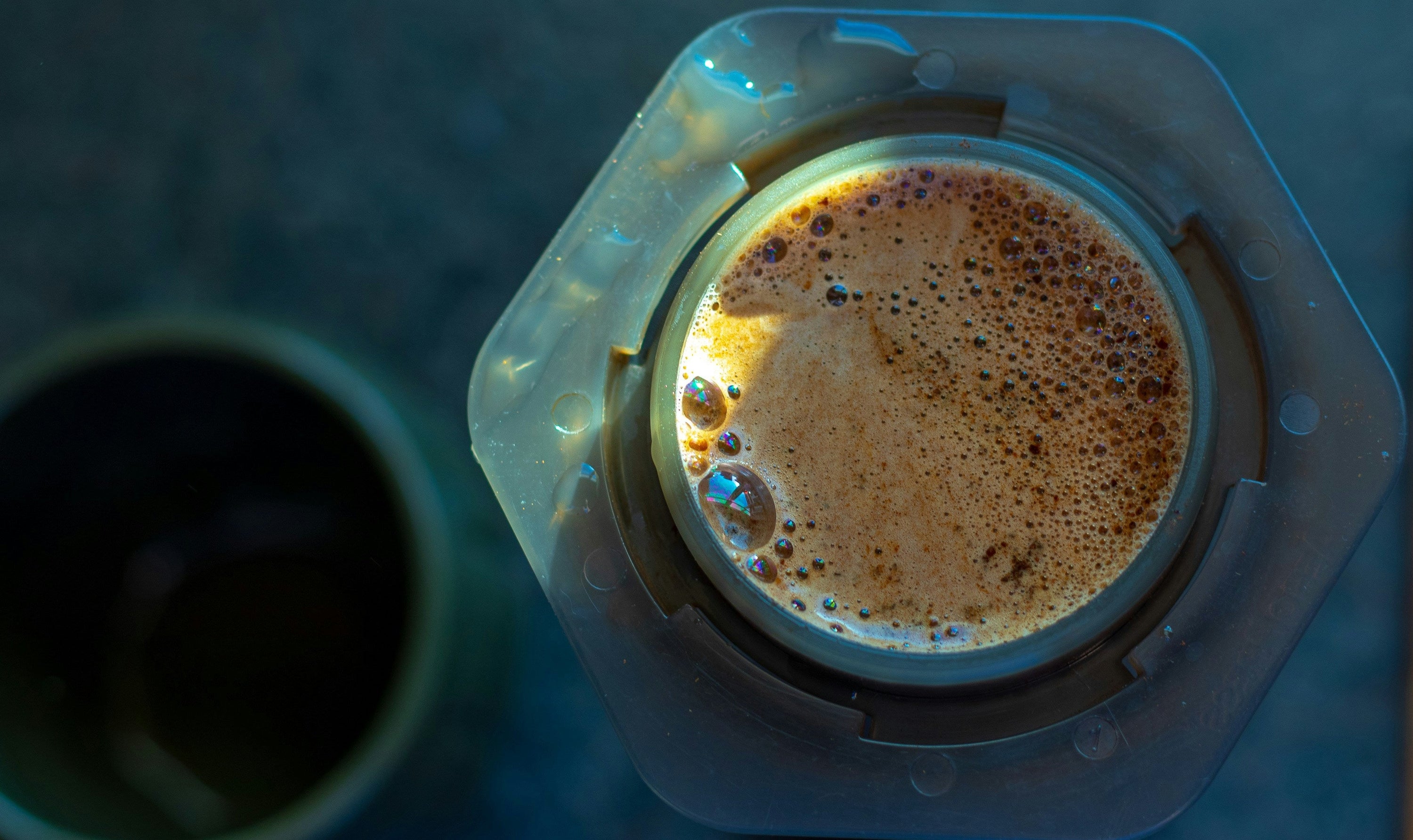 vertical photo of aeropress being used to brew coffee
