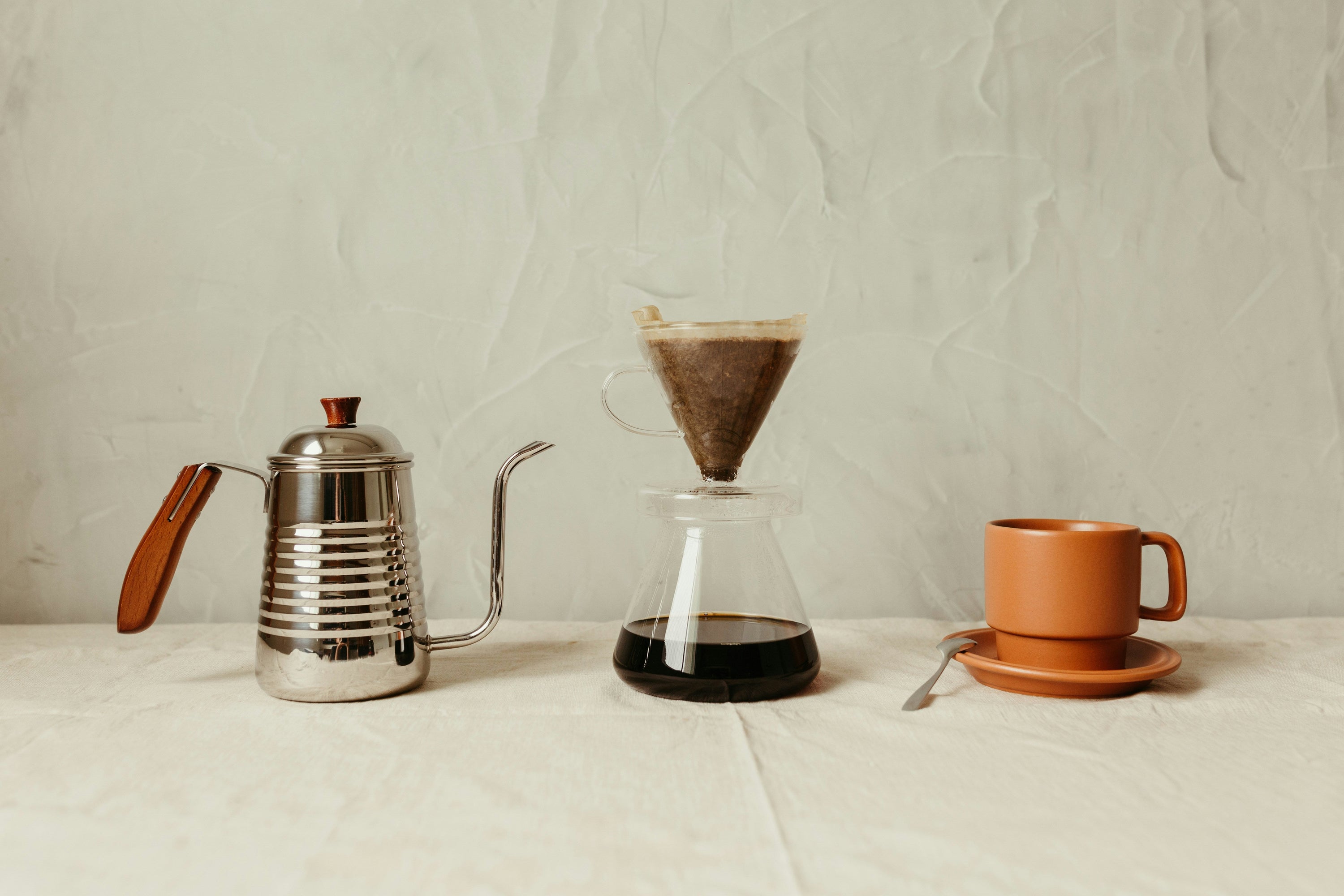 coffee carafe on countertop with coffee dripper and coffee cup