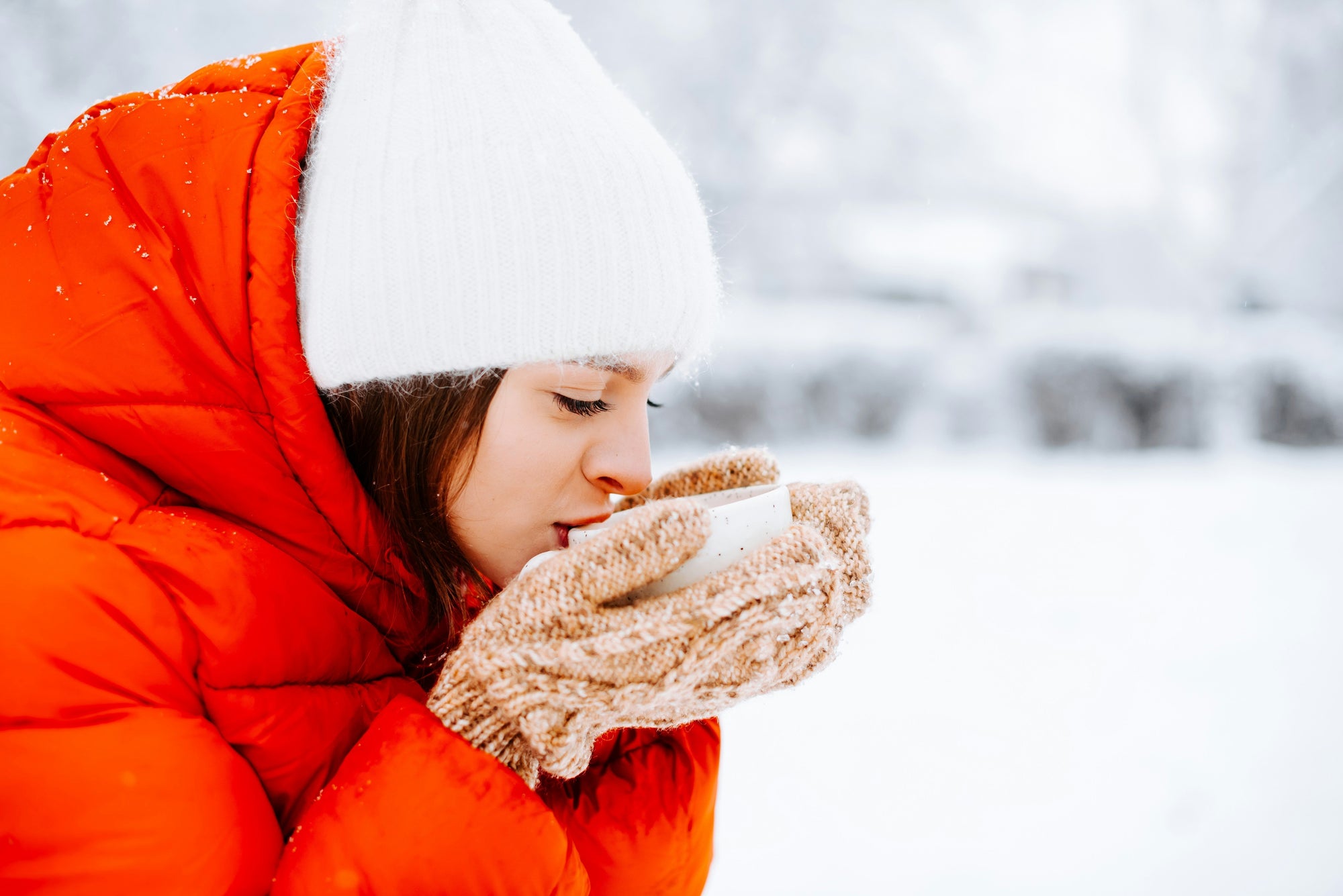 woman in cold and snow drinking coffee