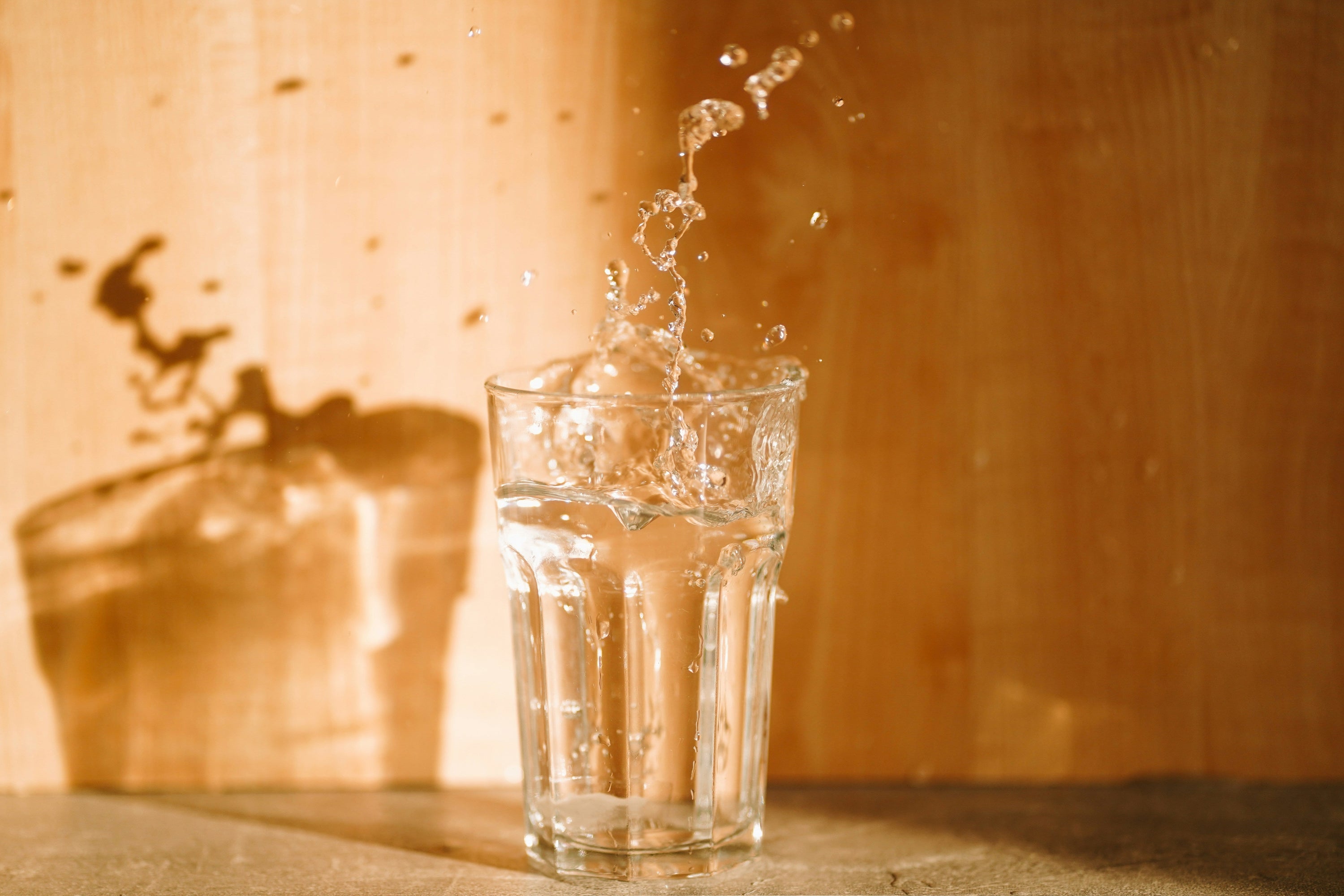 glass of water spilling on countertop