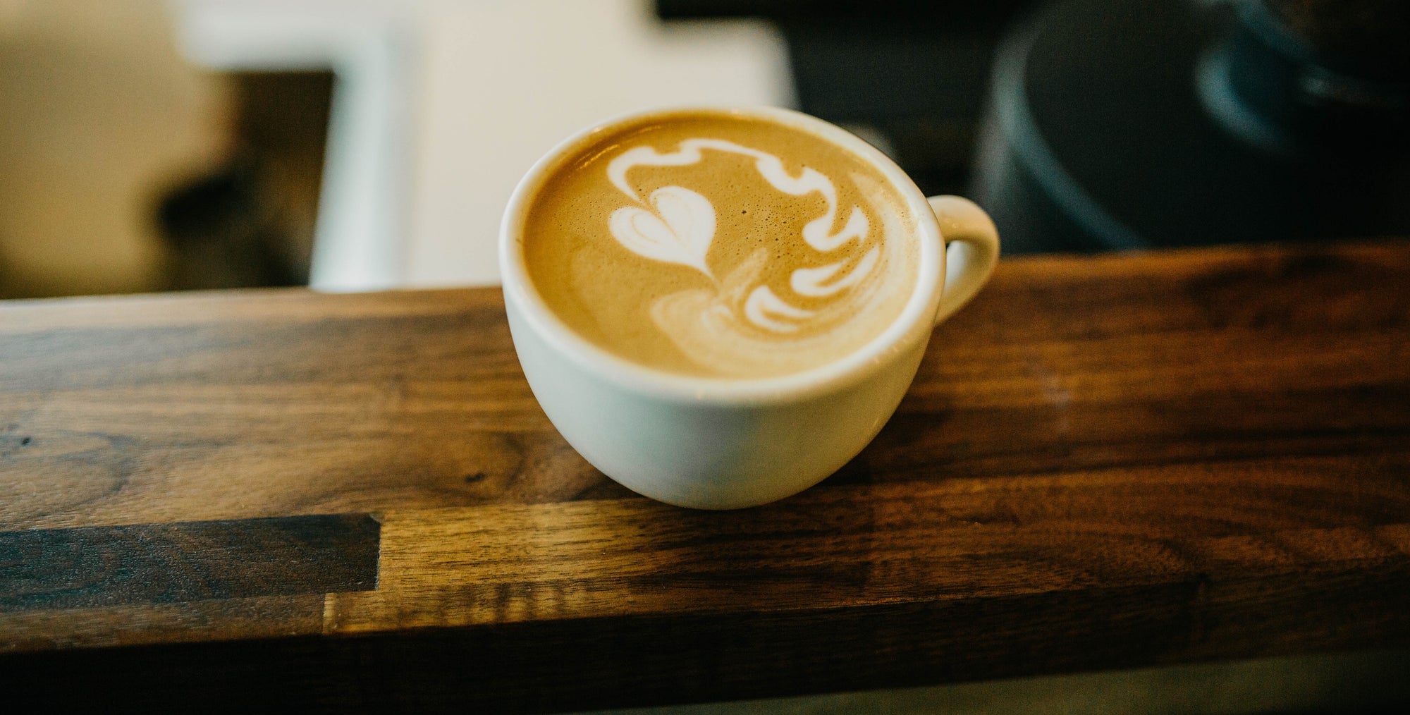 Flowing heart shape in foam of coffee in cup