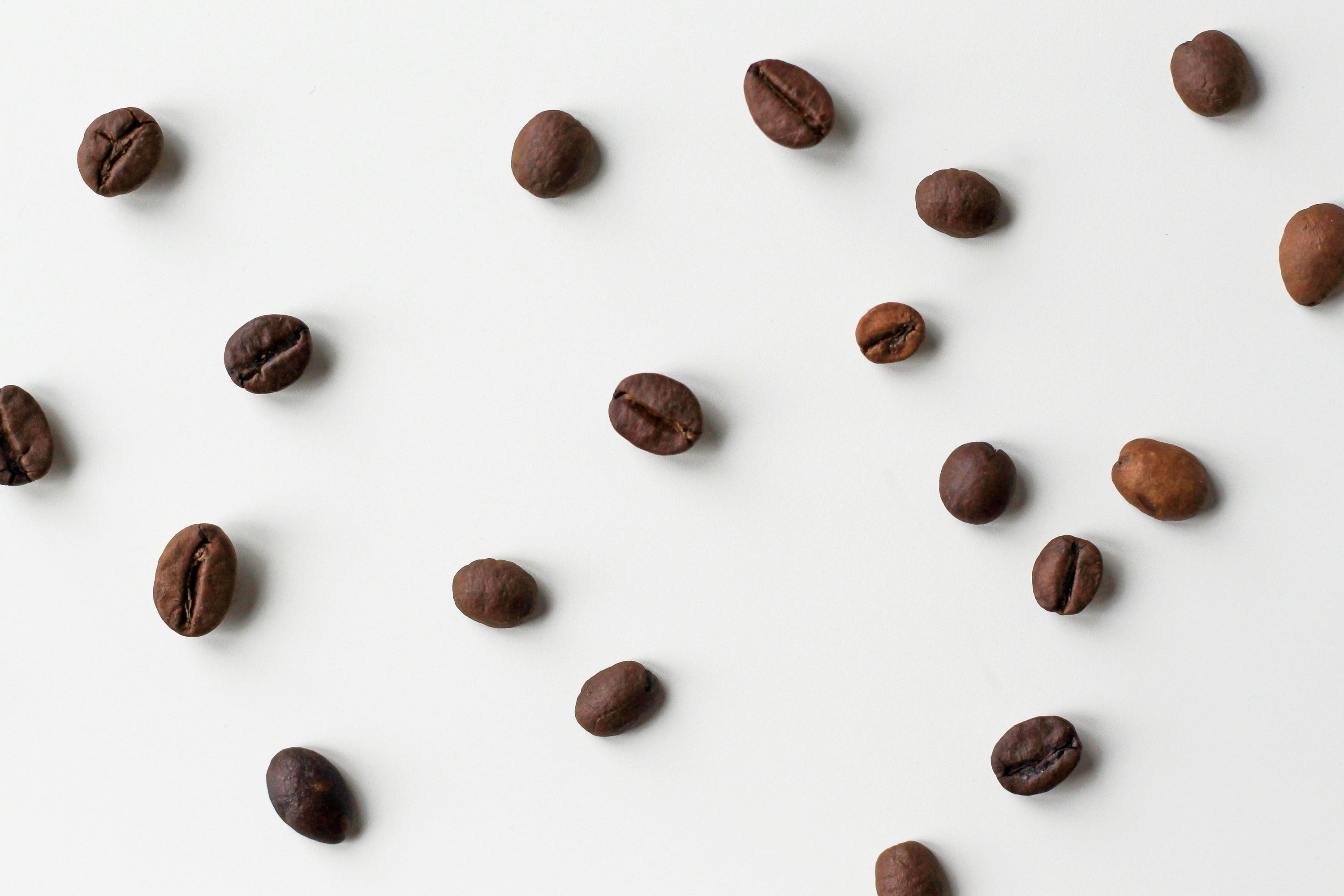 scattered coffee beans on a white table
