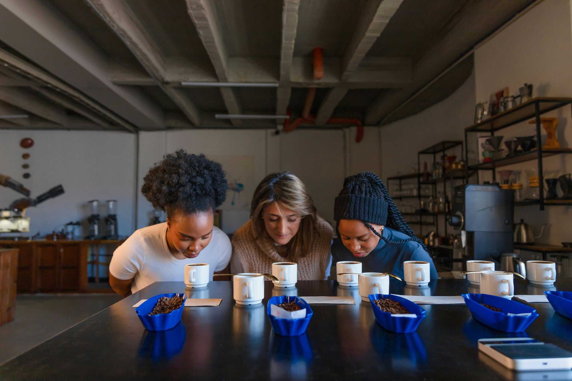 three people cupping coffee in large room