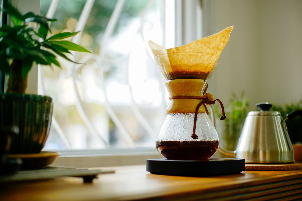 chemex coffee brewer on windowsill next to kettle