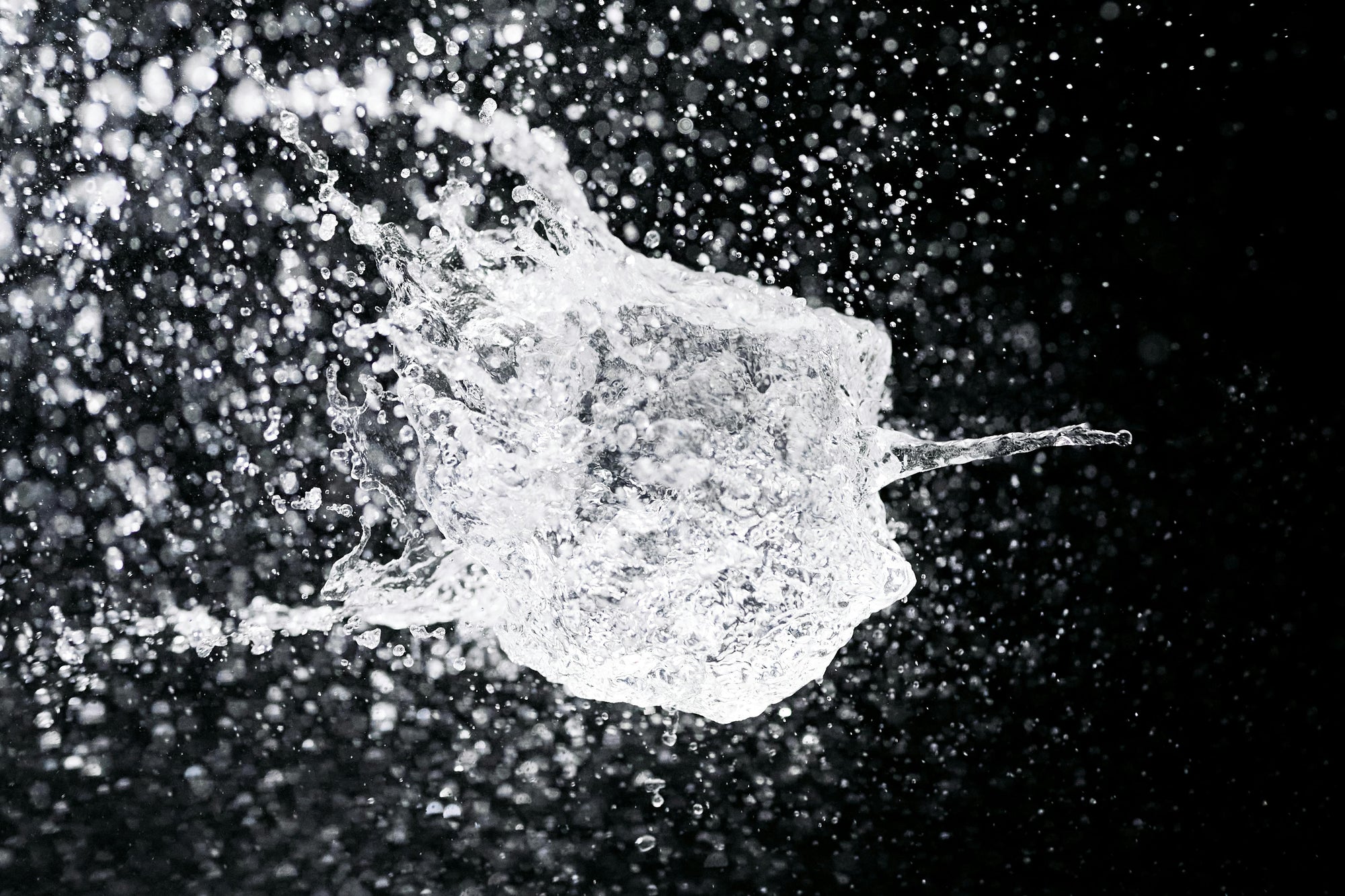 water suspended in the air against black background