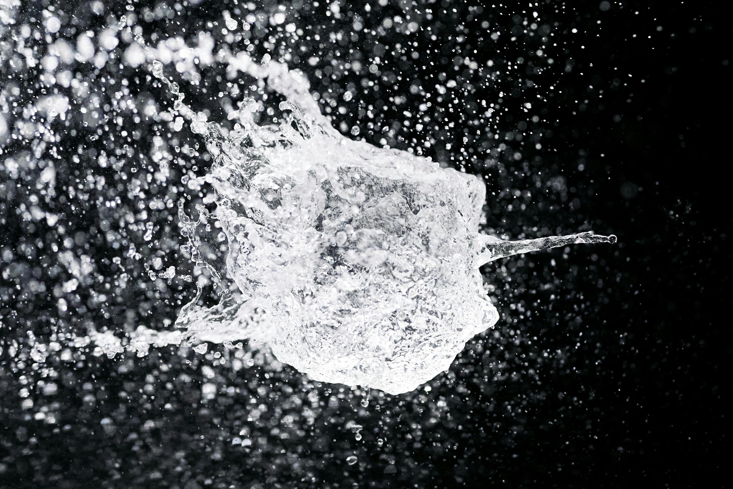 water suspended in the air against black background