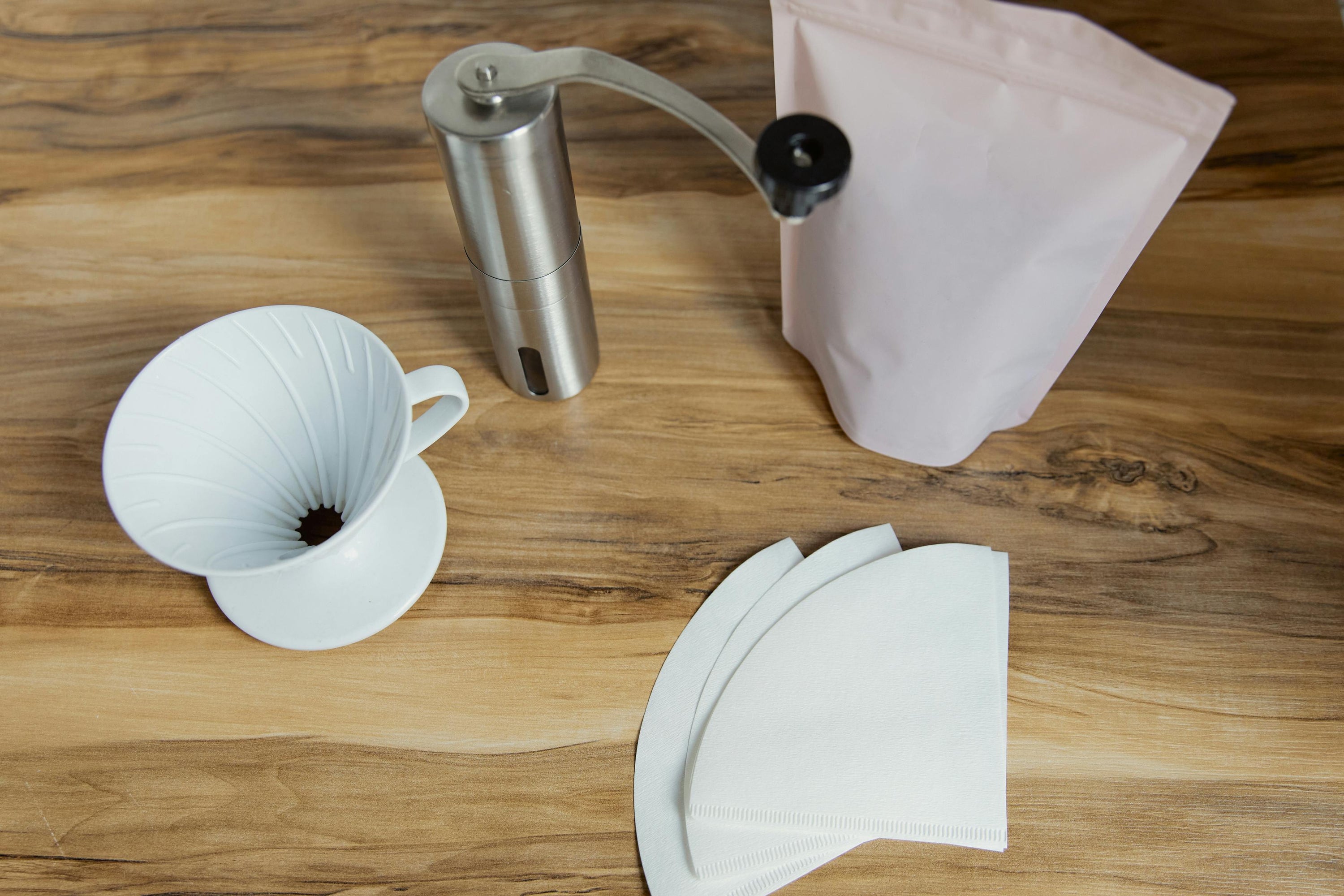 paper coffee filters sitting on countertop with other coffee brewing equipment