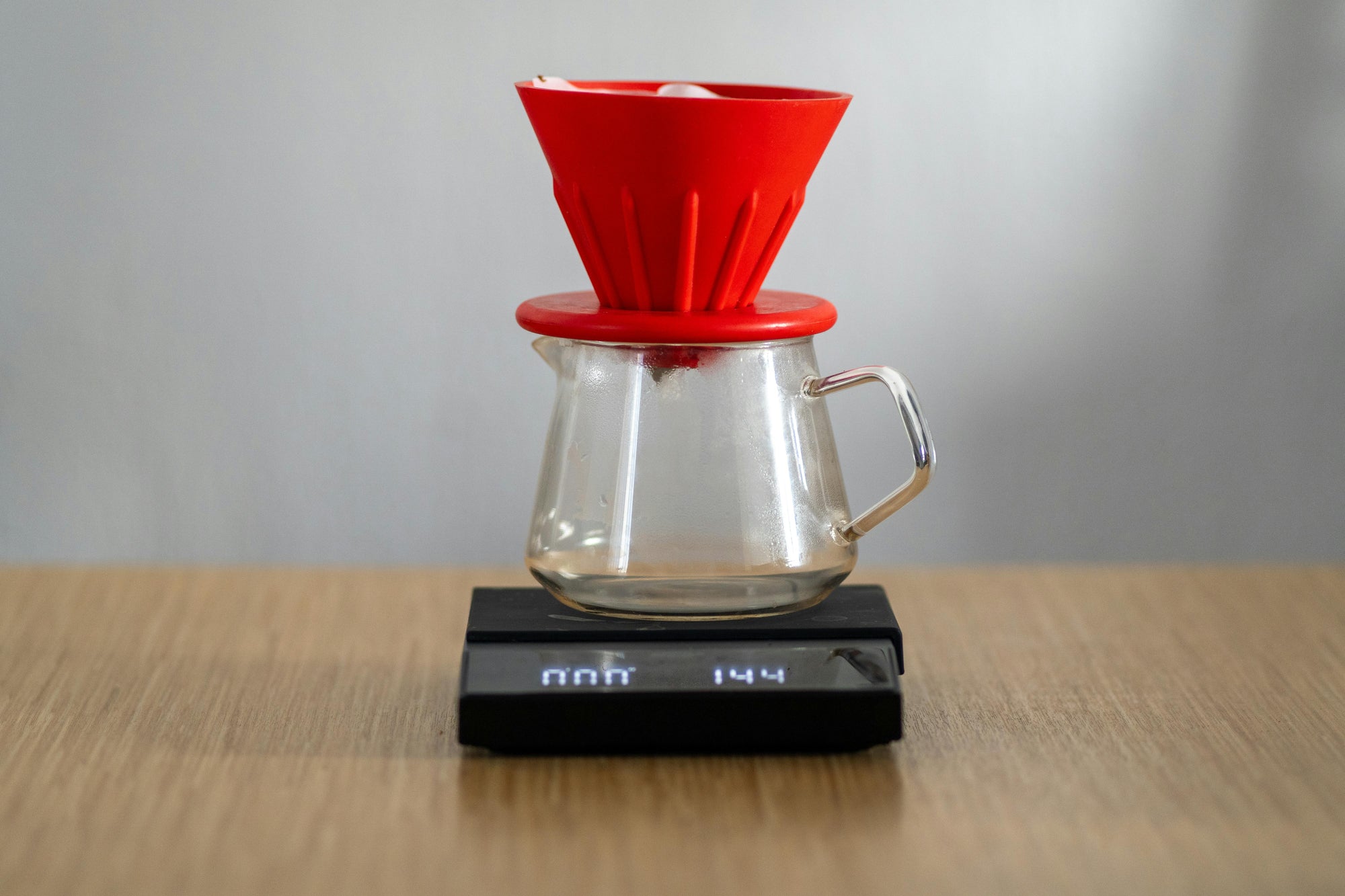 red coffee dripper on electronic coffee scales