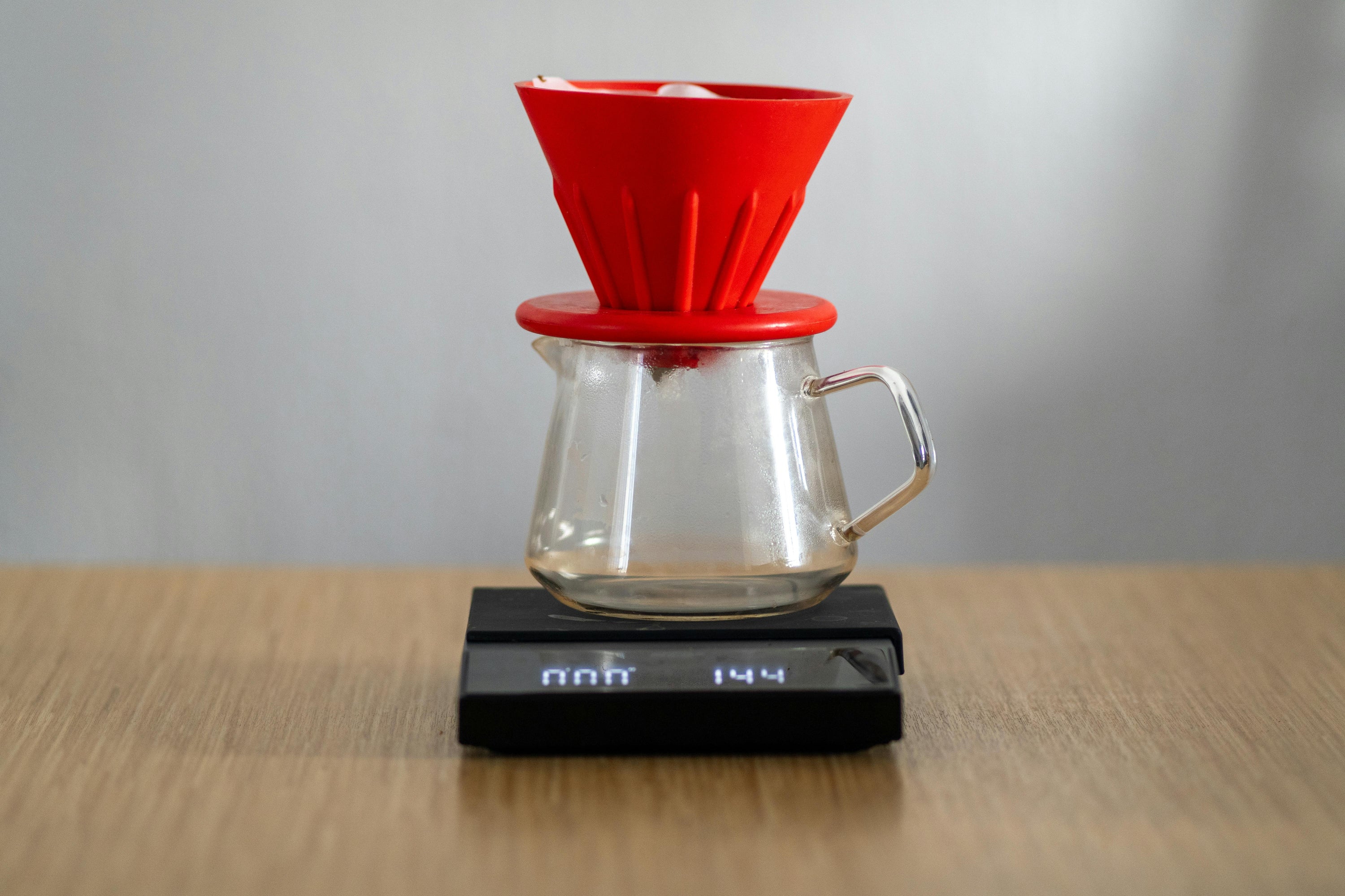 red coffee dripper on electronic coffee scales