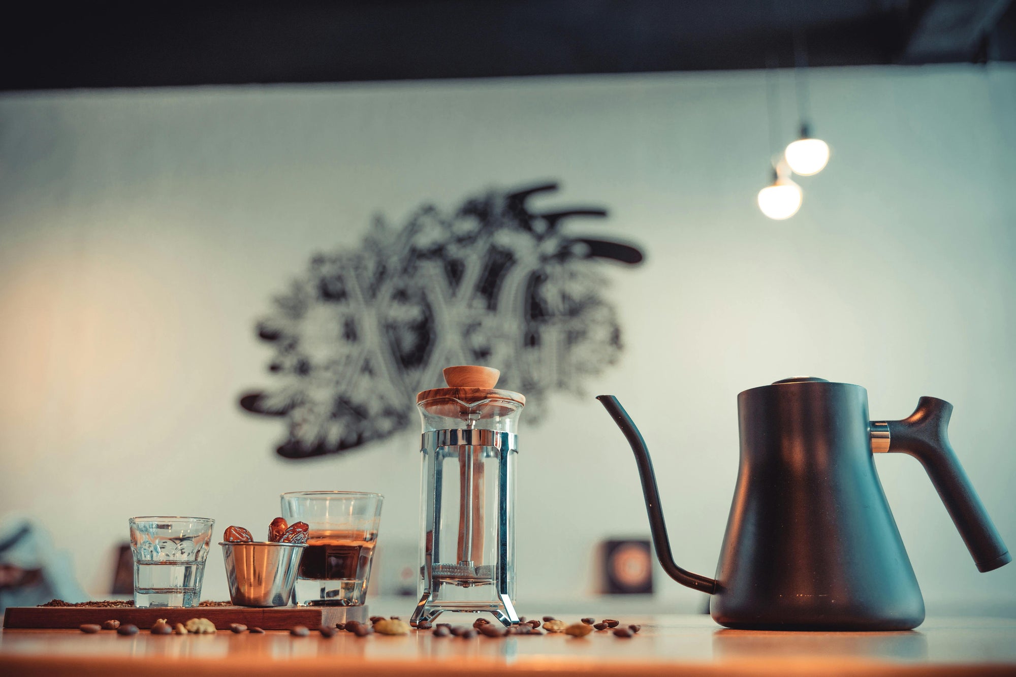 French press coffee brewer on table with goosenceck kettle