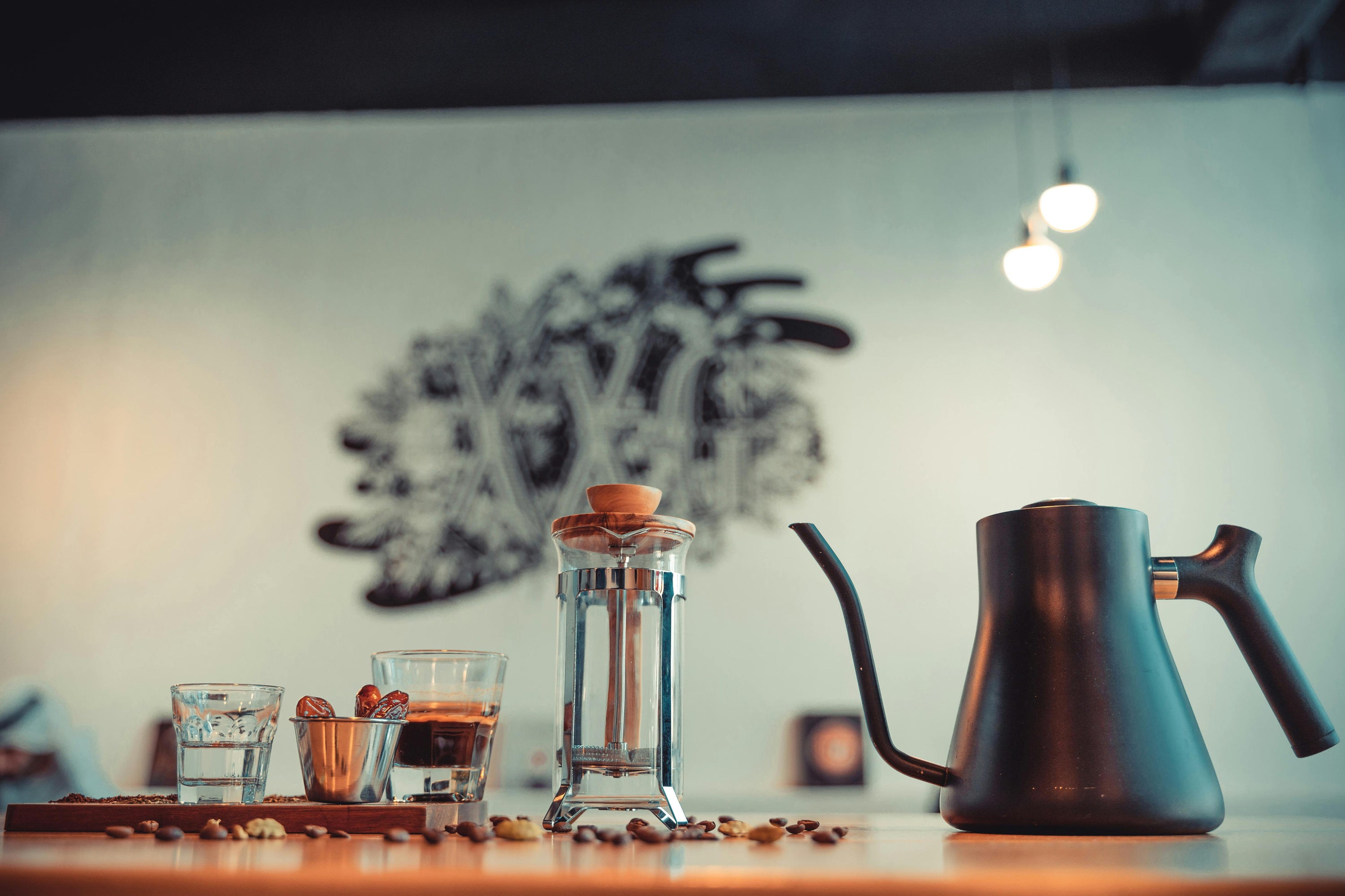 French press coffee brewer on table with goosenceck kettle
