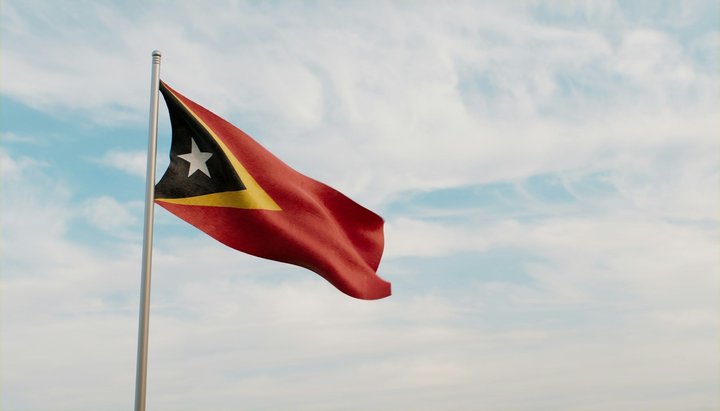 Flag of Timor-Leste flying against blue sky